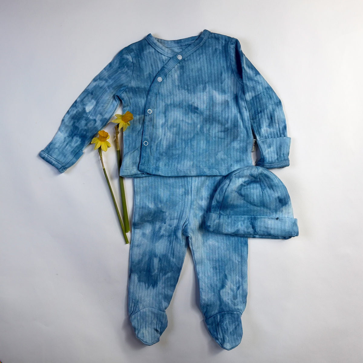 Blue ice-dyed cotton baby layette set, hand-dyed - top, footed pants and beanie styled with yellow daffodils